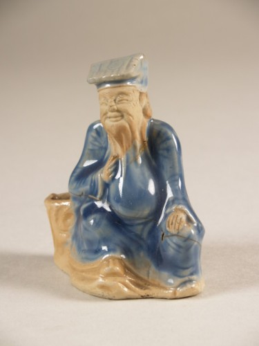 Waterdruppelaar in de vorm van een zittende man met blauwe mantel
